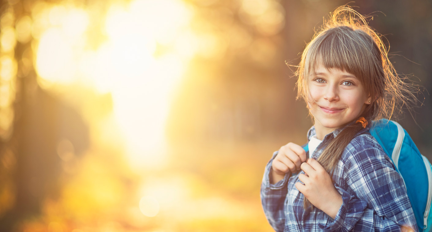 school age girl with book backpack